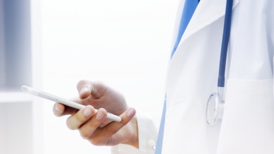 мужчина врач с мобильным телефоном в руках